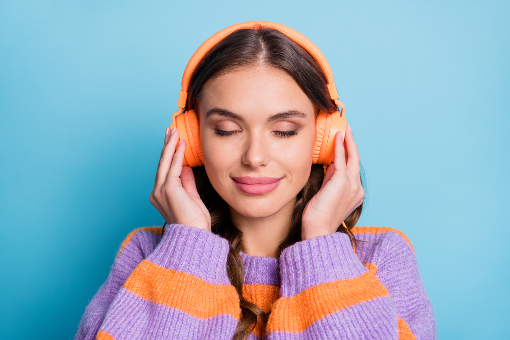 Фото чарівної дівчини закриті очі руки на навушниках слухайте улюблену одиночну ізольовану на синьому кольорі
 - Фото, зображення
