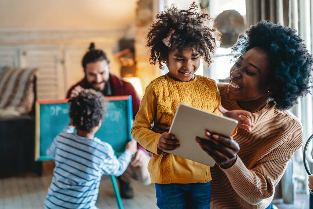 Boldog többnemzetiségű család segítségével tabletta játék nézni filmeket, pihentető otthon életmód koncepció - Fotó, kép