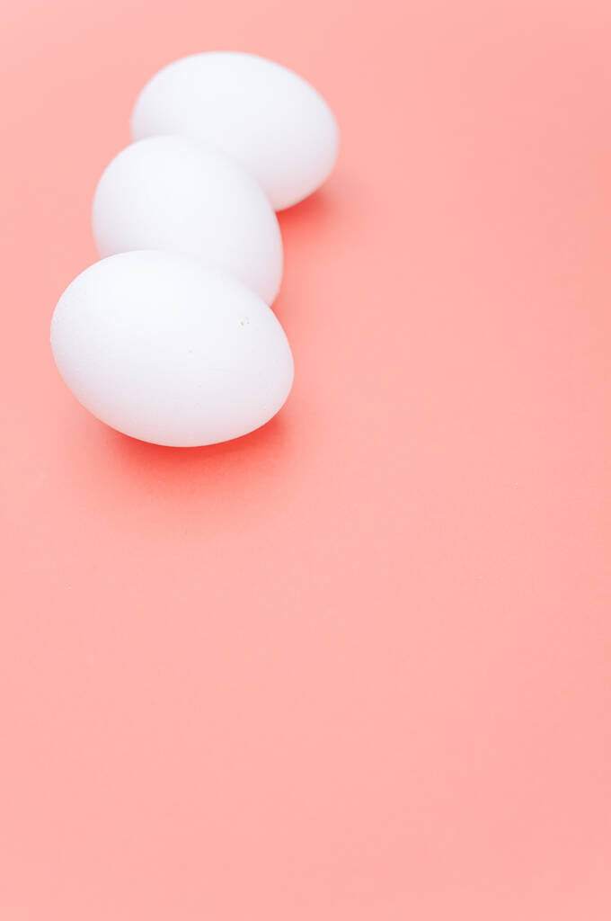 organiczne białe jaja na białym łososiu różowym powierzchni z miejsca na tekst - Zdjęcie, obraz