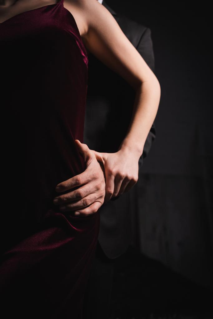 kivágott kilátás férfi megható csípő elegáns nő a sötétben - Fotó, kép