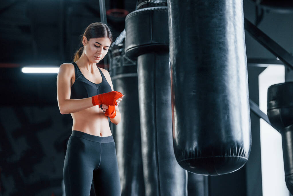 Młoda kobieta w sportowym stroju jest na siłowni, ma dzień ćwiczeń. Koncepcja boksu. - Zdjęcie, obraz
