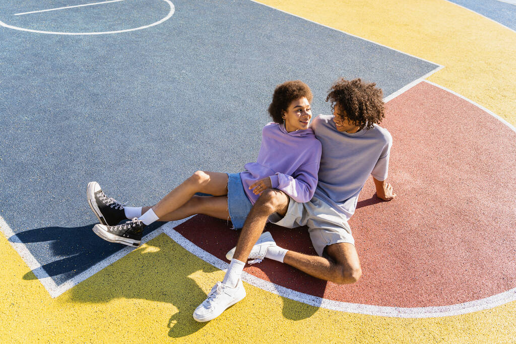 Interrassische junge Paare, die sich im Freien treffen, farbigen und modernen urbanen Hintergrund - multiethnische Menschen mit stilvoller und cooler urbaner Kleidung, die sich im Freien verbindet - Foto, Bild