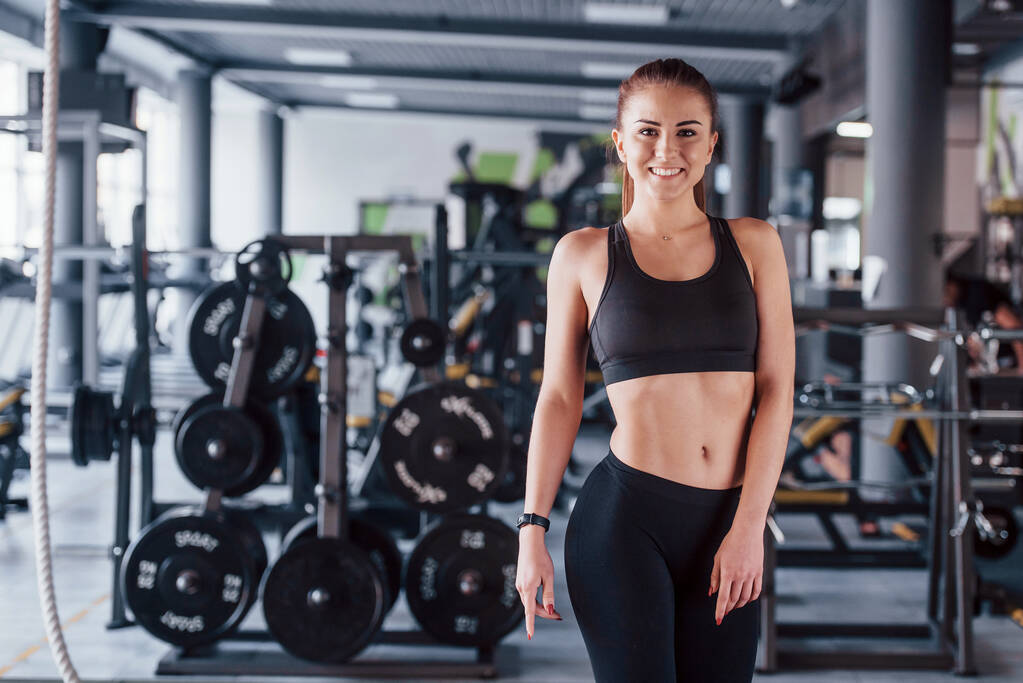 Jeune femme fitness entraîneur personnel avec bloc-notes debout dans la salle de gym. - Photo, image