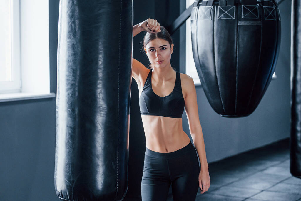 A fiatal nő sportos ruhában a tornateremben van edzésnapon. A boksz koncepciója. - Fotó, kép