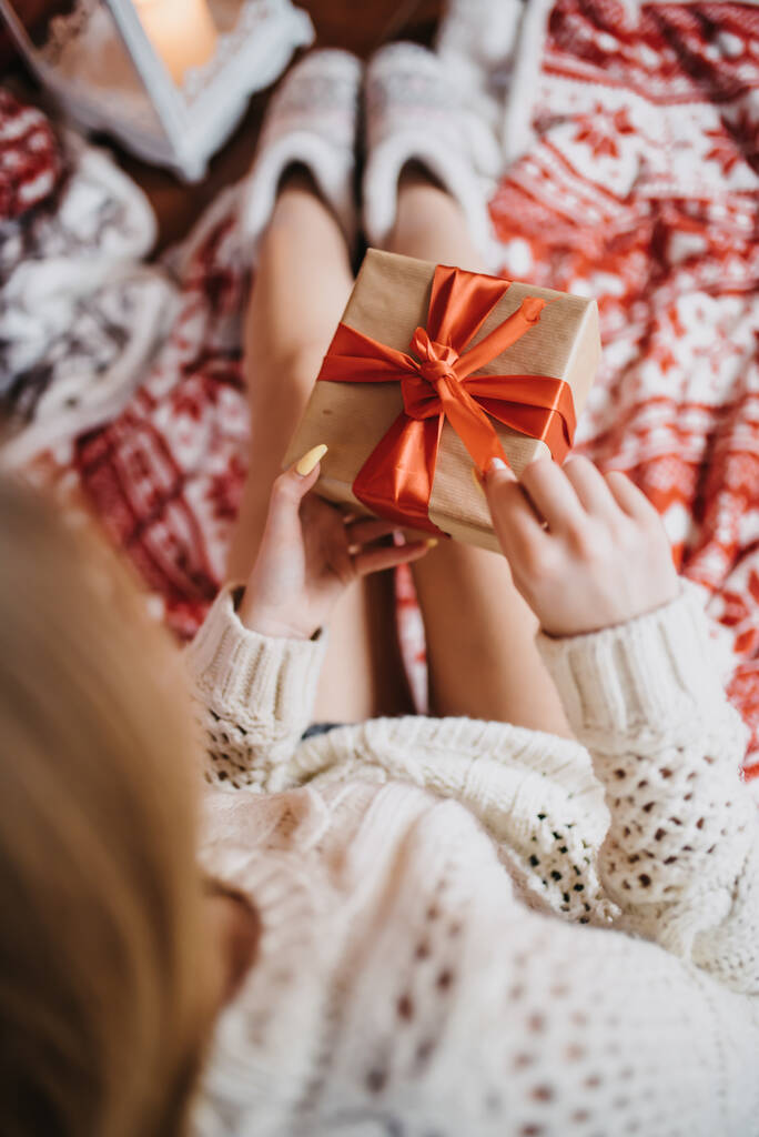 Женщина держит подарок рядом в канун Рождества - Фото, изображение