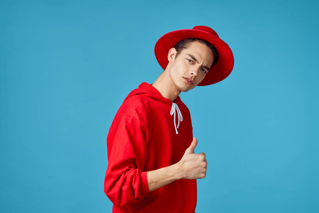 кудрявый парень в красном свитере позирует моде в стиле современного хипстера - Фото, изображение