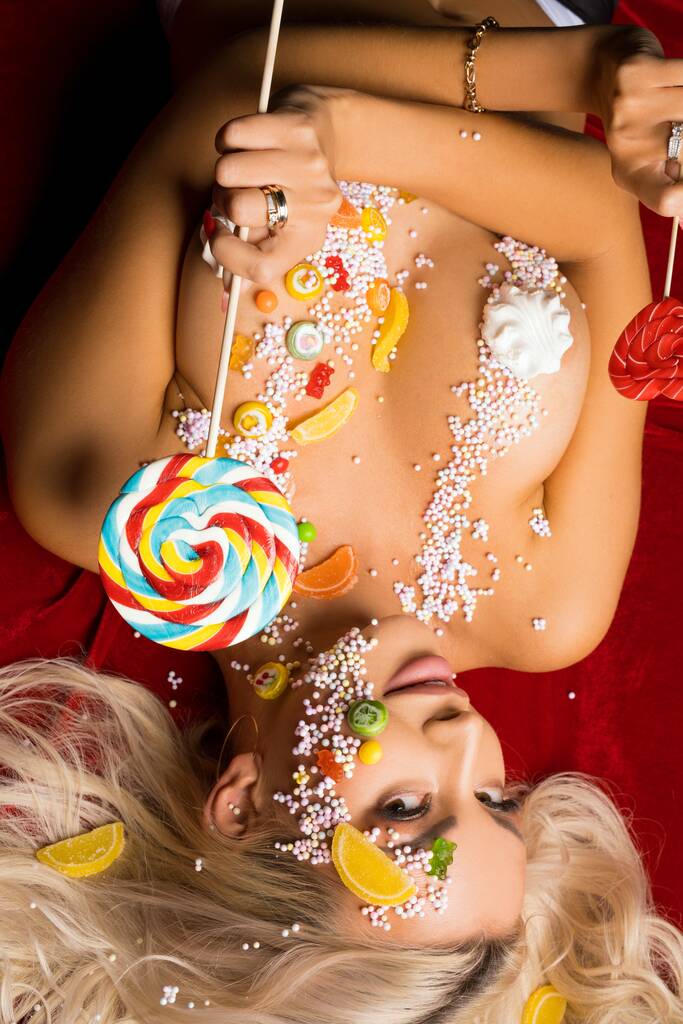 Naga blondynka pokryta kolorowymi cukierkami - Zdjęcie, obraz