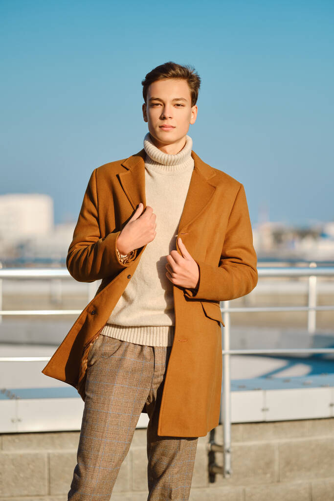 Jaro - podzimní oblečení. Pouliční. Mladý muž v kostkovaných kalhotách, svetr zábaly vlněný kabát. - Fotografie, Obrázek