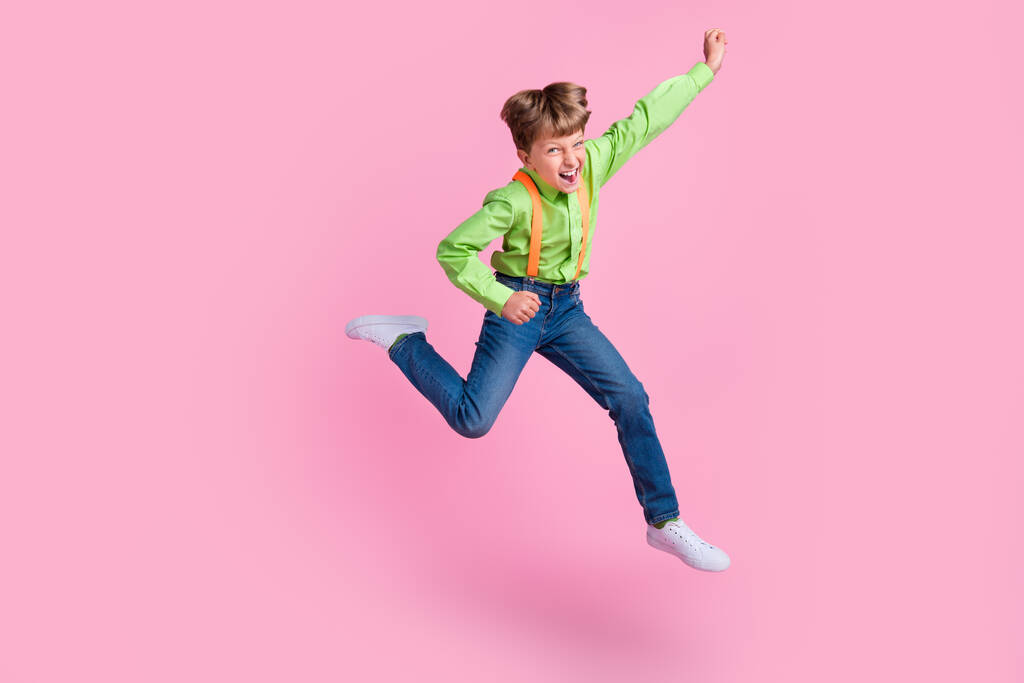 Longitud completa vista del tamaño del cuerpo de la atractiva alegre suerte de moda chico saltando regocijo aislado sobre rosa pastel color fondo - Foto, Imagen
