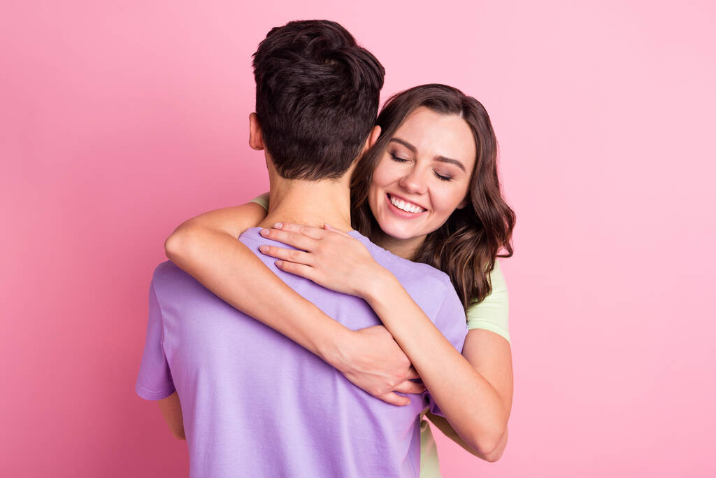 Retrato de atractiva pareja alegre amorosa tierna y tierna de ensueño abrazando aislado sobre fondo de color pastel rosa - Foto, imagen