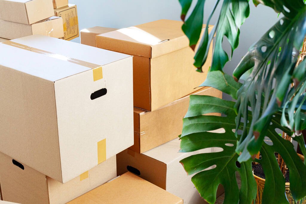 Casa concepto móvil con cajas de cartón apiladas en una habitación - Foto, imagen