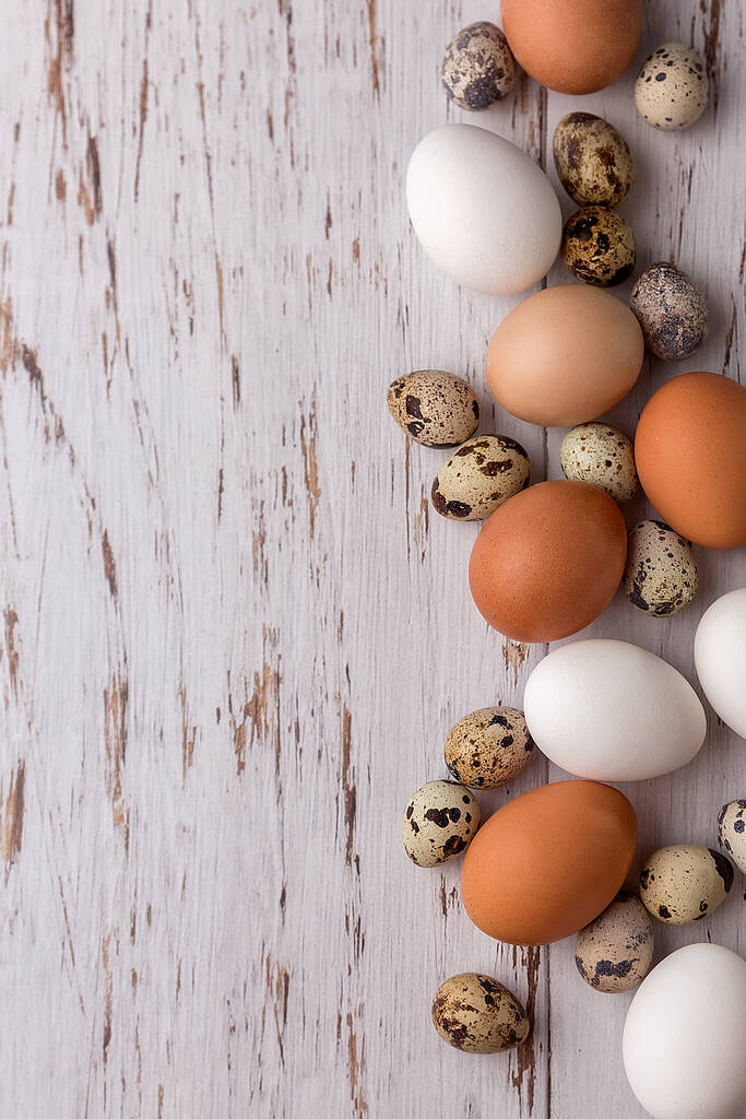 Húsvéti kép fürj és csirke tojás egy könnyű fa háttér. A húsvét minimális koncepciója. Húsvéti üdvözlőlap, benne a szöveggel.. - Fotó, kép