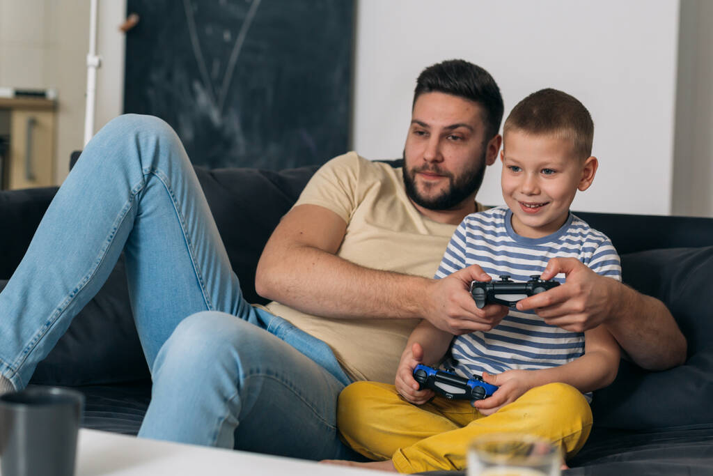 家庭でビデオゲームをしている父と息子は - 写真・画像