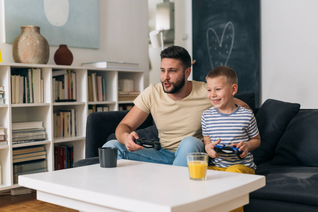 padre e hijo jugando videojuegos en casa - Foto, Imagen