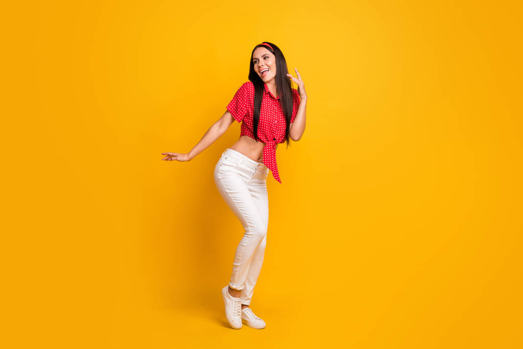 Полная длина фото милой очаровательной молодой девушки в красной рубашке танцуя изолированный желтый цвет фона - Фото, изображение