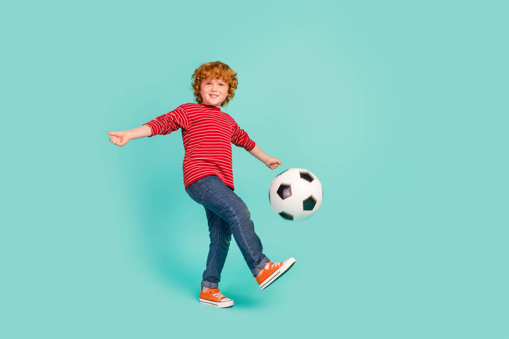 Full size foto di funky ragazzino giocare a calcio usura camicia jeans scarpe da ginnastica isolato su sfondo blu - Foto, immagini