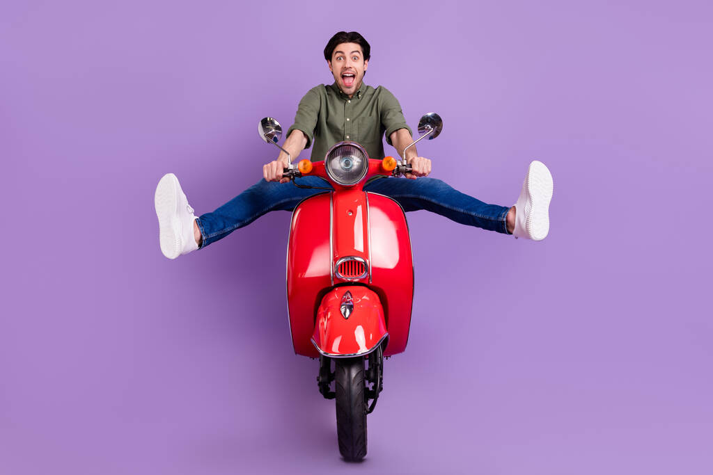 Повна довжина фотографії позитивного веселого божевільного молодого чоловіка їздити на велосипеді насолоджуватися швидкістю ізольовано на фіолетовому кольоровому фоні
 - Фото, зображення