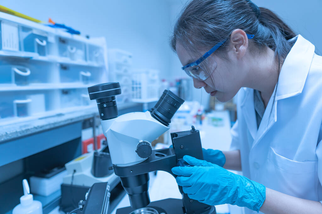 Asijský vědec pracující v laboratoři, vědec prevence a ničení nových kmenů koronaviru pomocí mikroskopie - Fotografie, Obrázek