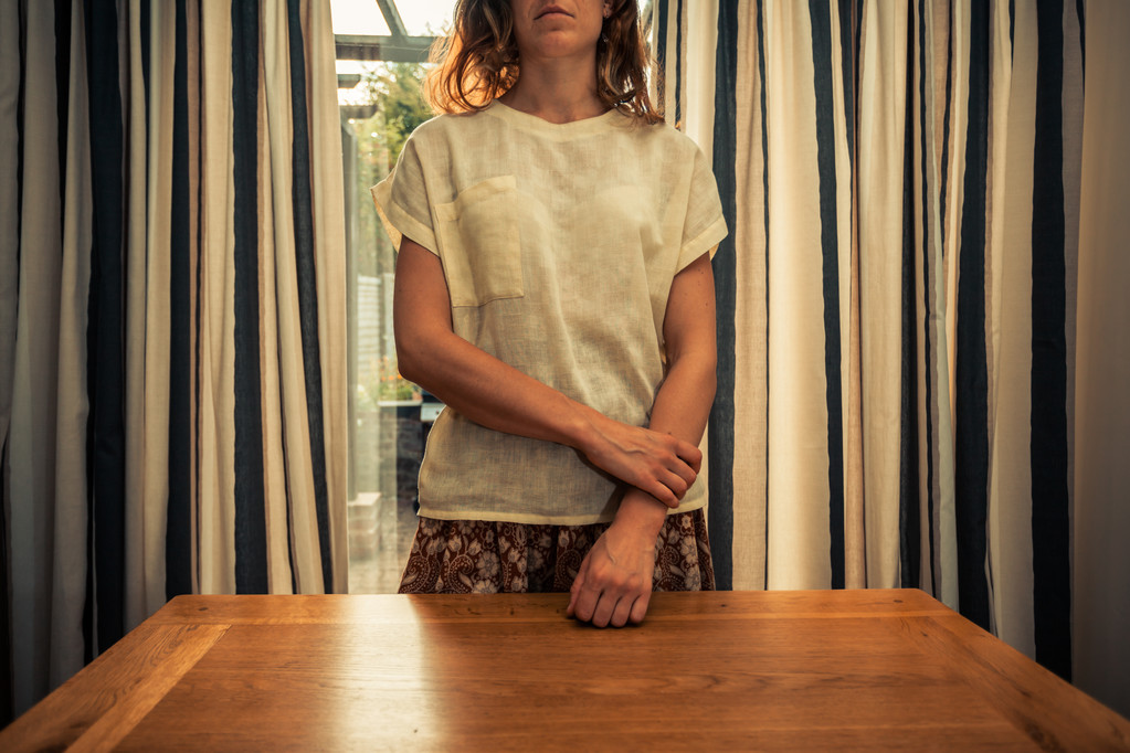 Giovane donna in piedi da tende di porte francesi
 - Foto, immagini