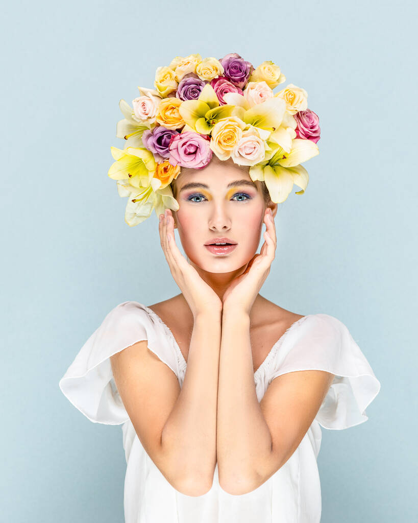 Geheimnisvolles junges Mädchen blickt mit Blumen im Kopf in die Kameralinse  - Foto, Bild