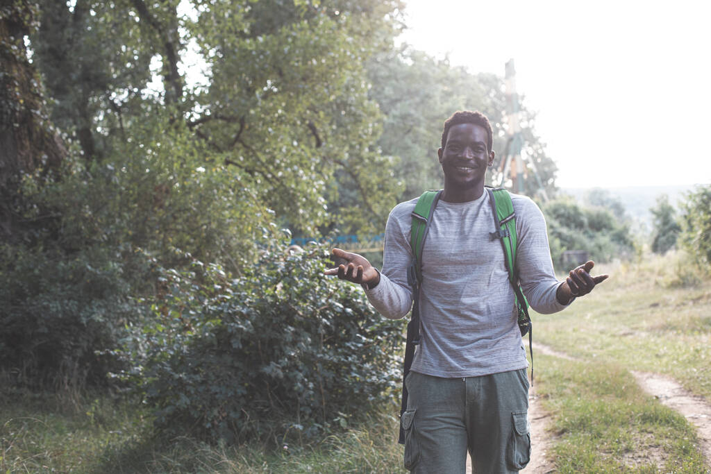 Sırt çantalı genç adam ormanda yürüyüş yapıyor. - Fotoğraf, Görsel
