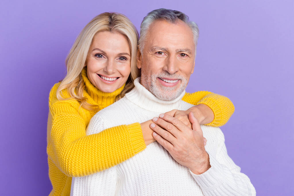 Фото мрійливого чарівного старшого чоловіка, одягненого в трикотажні светри, обіймають усміхнений ізольований фіолетовий кольоровий фон
 - Фото, зображення