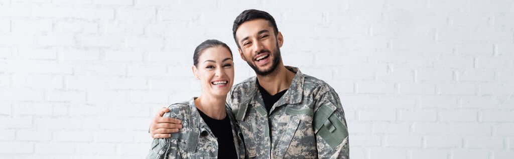 Sorrindo homem em camuflagem uniforme abraçando esposa em casa, banner  - Foto, Imagem