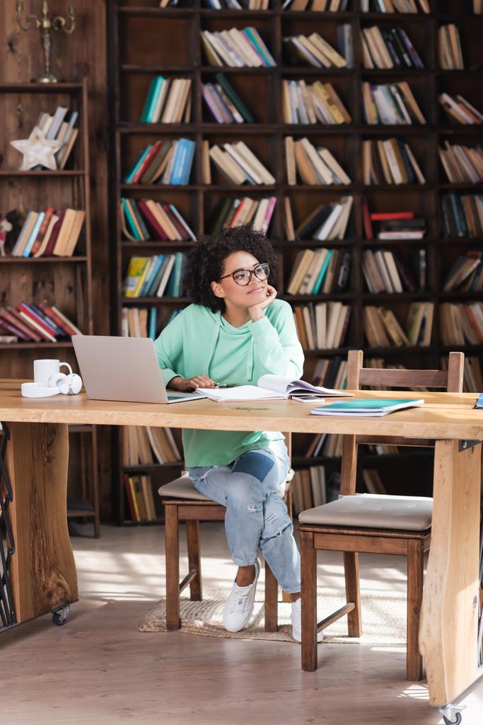 mietteliäs afrikkalainen amerikkalainen opiskelija silmälasien opiskelu verkossa lähellä kannettavaa tietokonetta  - Valokuva, kuva