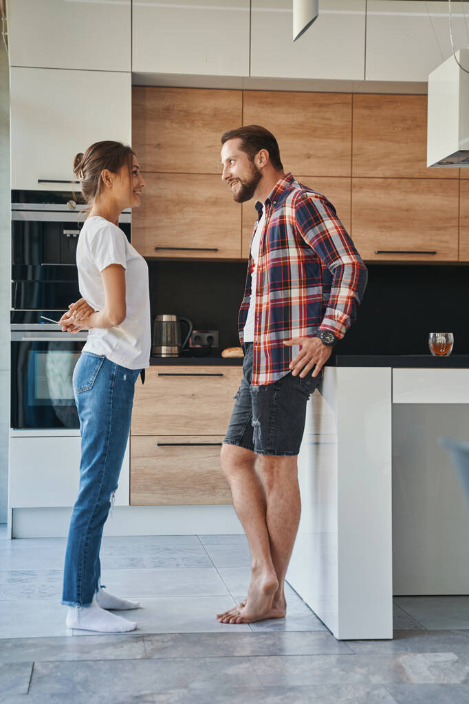 Komea valkoihoinen mies, jolla on keskustelu tyttöystävänsä kanssa kotona asunnoissa - Valokuva, kuva
