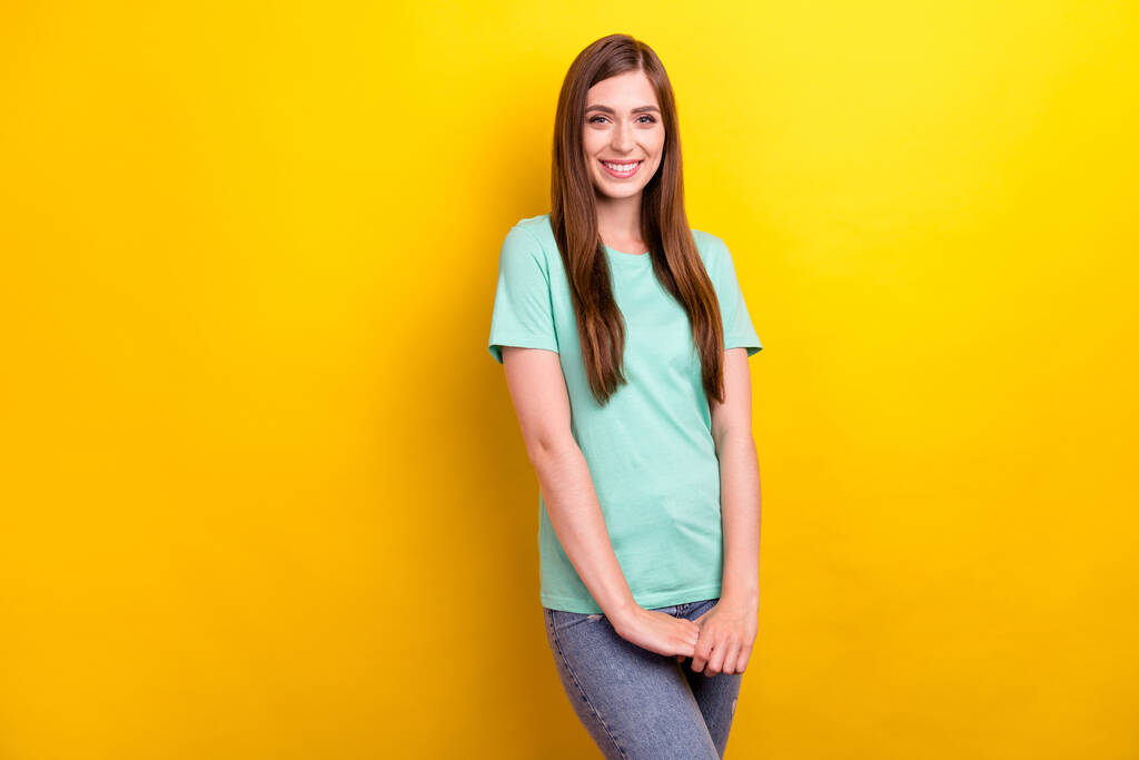 Photo of cute brunette hairdo millennial lady hold hands wear teal t-shirt isolated on yellow color background - Photo, Image
