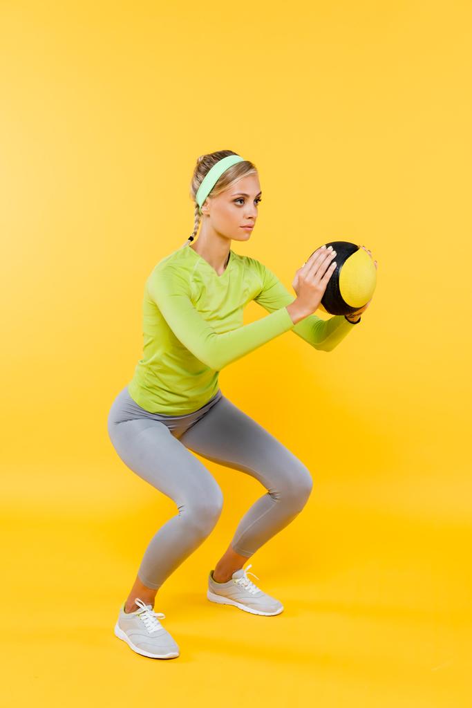 täyspitkä näkymä ohut nainen harmaa leggingsit tekee istua ups pallo keltainen - Valokuva, kuva