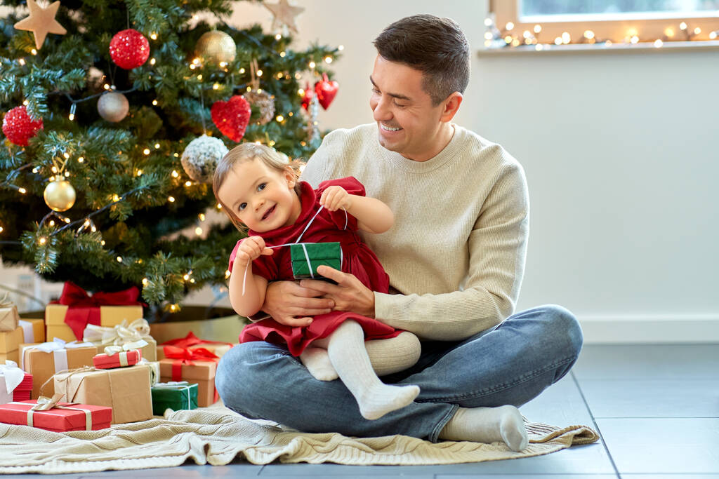 クリスマスに幸せな父親と赤ん坊の娘 - 写真・画像
