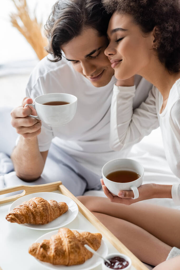 satisfeito e interracial casal tomando café da manhã na cama  - Foto, Imagem