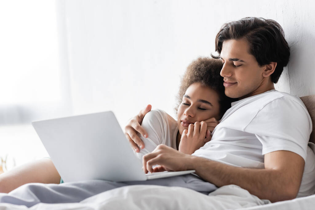 mulher americana africana dormindo no peito do namorado com laptop  - Foto, Imagem