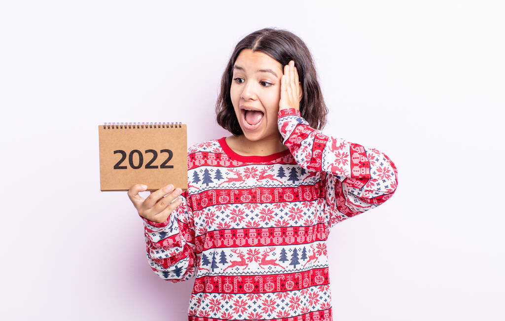 kaunis nuori nainen tuntee onnellinen, innoissaan ja yllättynyt. 2022 kalenterin käsite - Valokuva, kuva