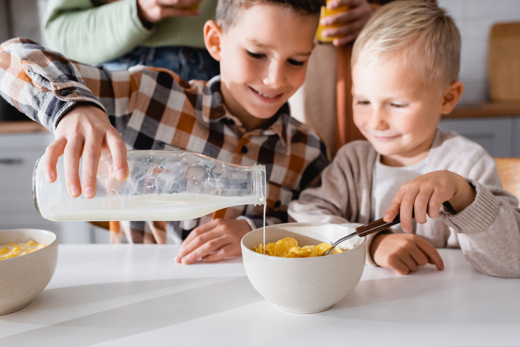 Kid Pouring Milk Into Bowl With Tasty Free Stock Photo and Image