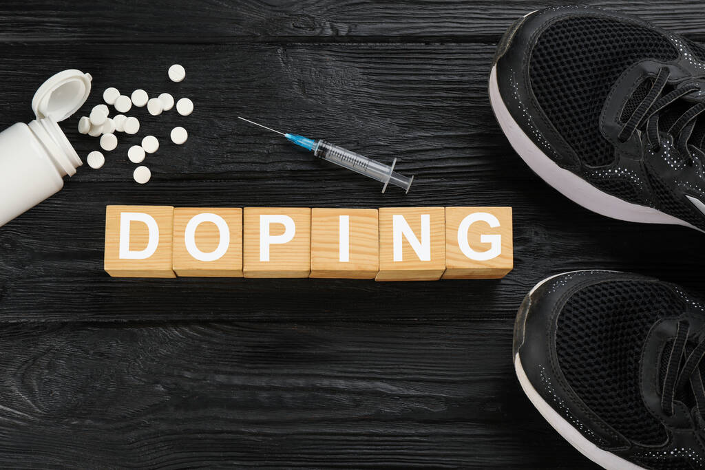 Cubos con palabra Doping, zapatos deportivos y drogas sobre fondo de madera negro, plano lay - Foto, Imagen