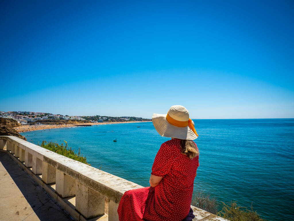 Woman sitting at seaside and looking at Albufeira's beach - Photo, Image
