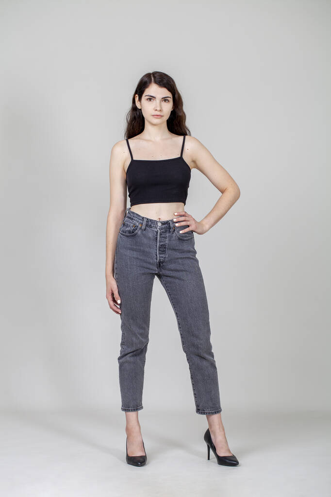 Retrato de cuerpo completo de una joven hermosa modelo morena en jeans grises - Foto, imagen