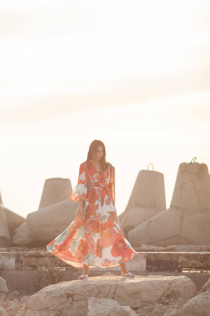 Kaunis nainen pitkä punainen mekko lähellä aallonmurtajaa, kävellä meren rannalla - Valokuva, kuva