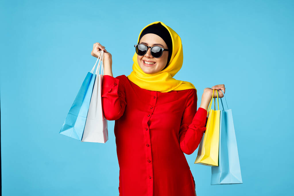 muslim žena v hidžáb nakupování zábava modré pozadí - Fotografie, Obrázek