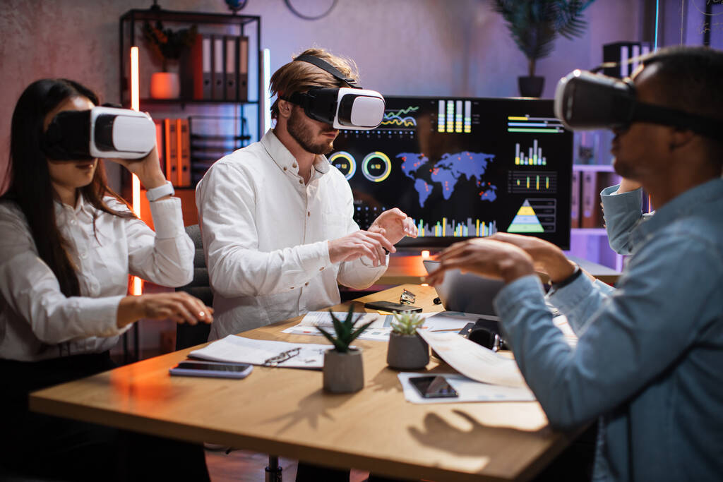 Groupe de spécialistes IT divers utilisant un casque VR au bureau - Photo, image
