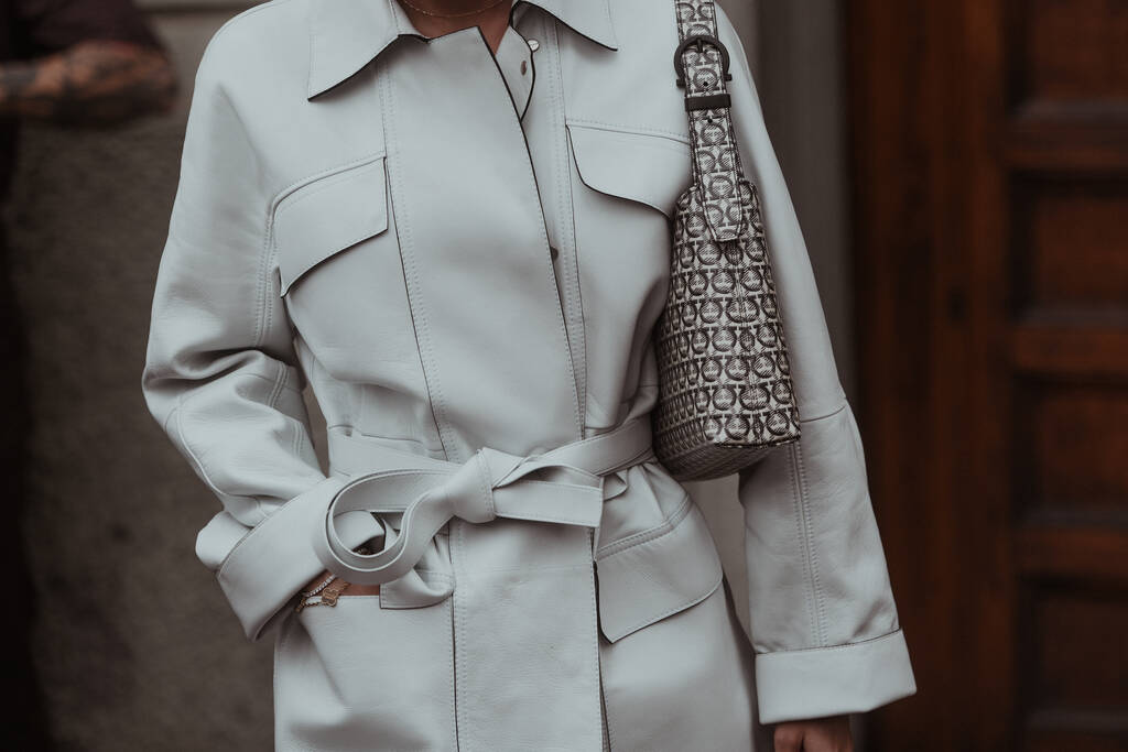 Milão, Itália - 22 de setembro de 2021: Roupa de rua, mulher elegante vestindo creme casaco branco, bolsa com estampa e botas nas ruas de Milão, Itália. - Foto, Imagem