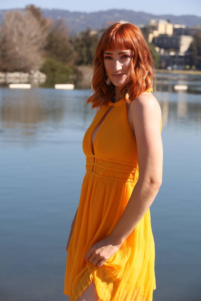 Foto di una bella ragazza bianca in un bellissimo vestito in piedi di fronte a un lago - Foto, immagini