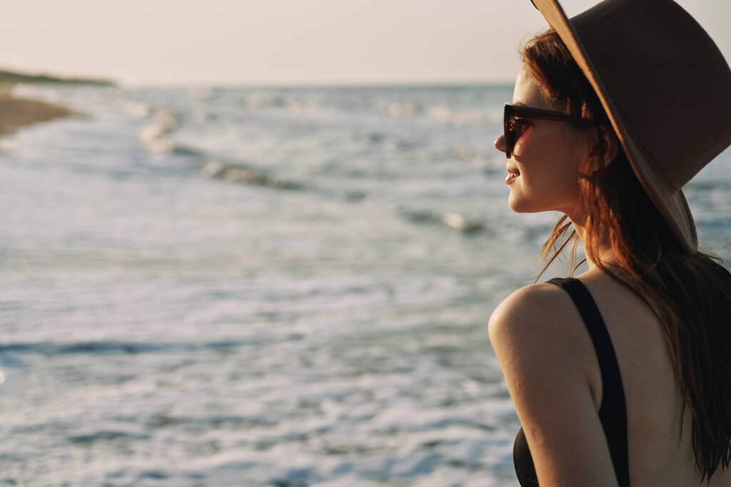 γυναίκα περπάτημα στην παραλία καπέλο ταξίδια διακοπές ήλιος - Φωτογραφία, εικόνα