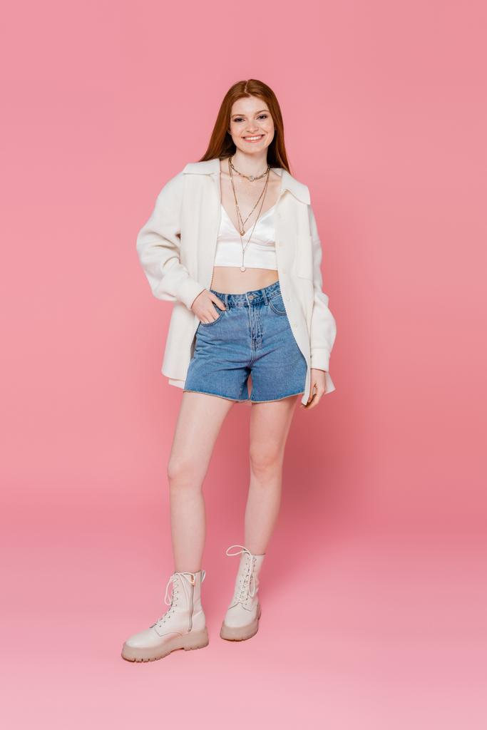 Full length of pretty and smiling woman posing on pink background - Photo, Image