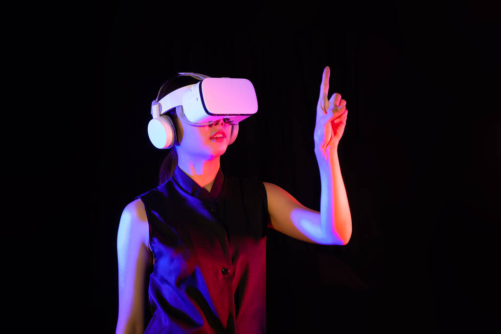 Aziatisch vrouw in vr bril, het spelen van video games met virtual reality headset, wijzen iets met de handen, Metaverse concepten - Foto, afbeelding