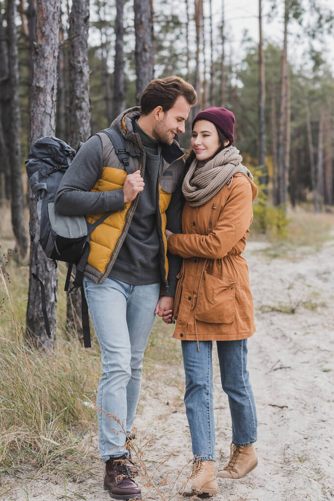 happy young couple in autumn outfit hiking in forest - Photo, Image