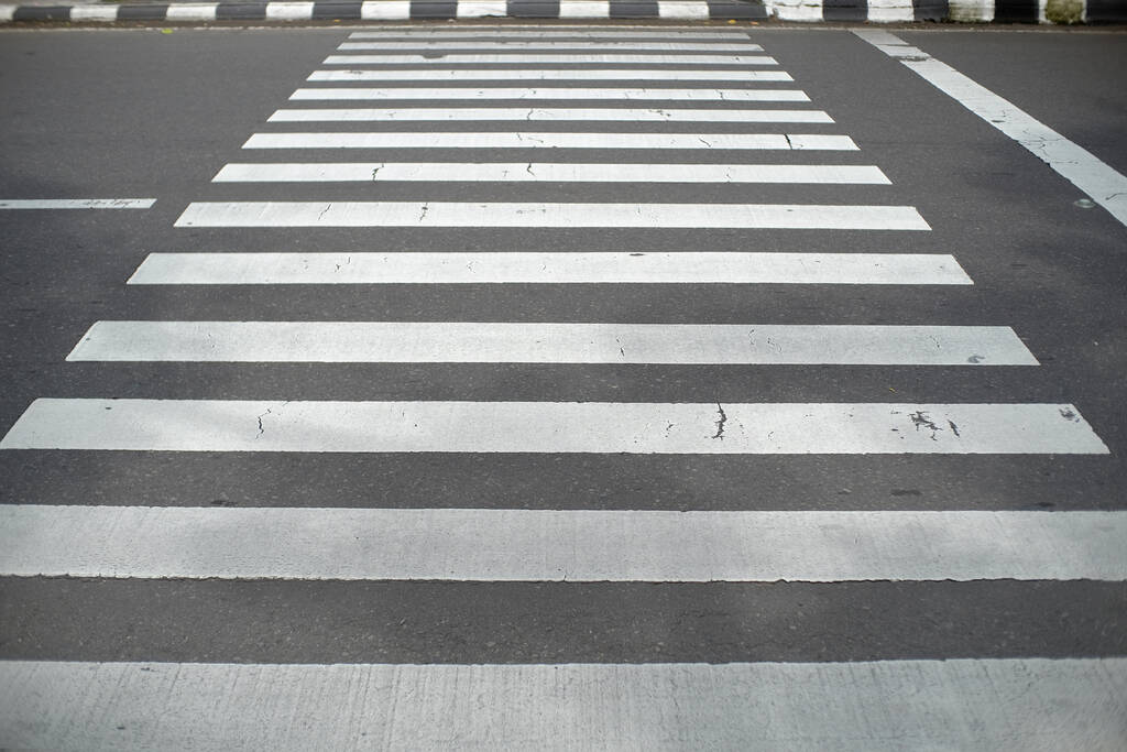 Markierungslinien für Kreuzungen sowie Schilder zur Vorsicht für Verkehrsteilnehmer.  - Foto, Bild