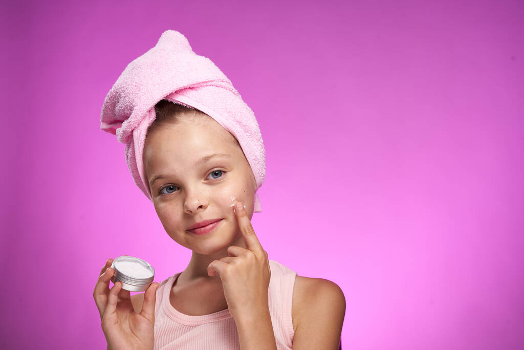 menina com uma toalha em sua cabeça cosméticos decoração close-up roxo fundo - Foto, Imagem